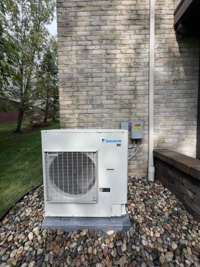Daikin air conditioner on a gravel pad next to a brick home in South Lyon, Michigan
